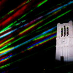 Lasers shine around the Memorial Belltower during an evening light show.