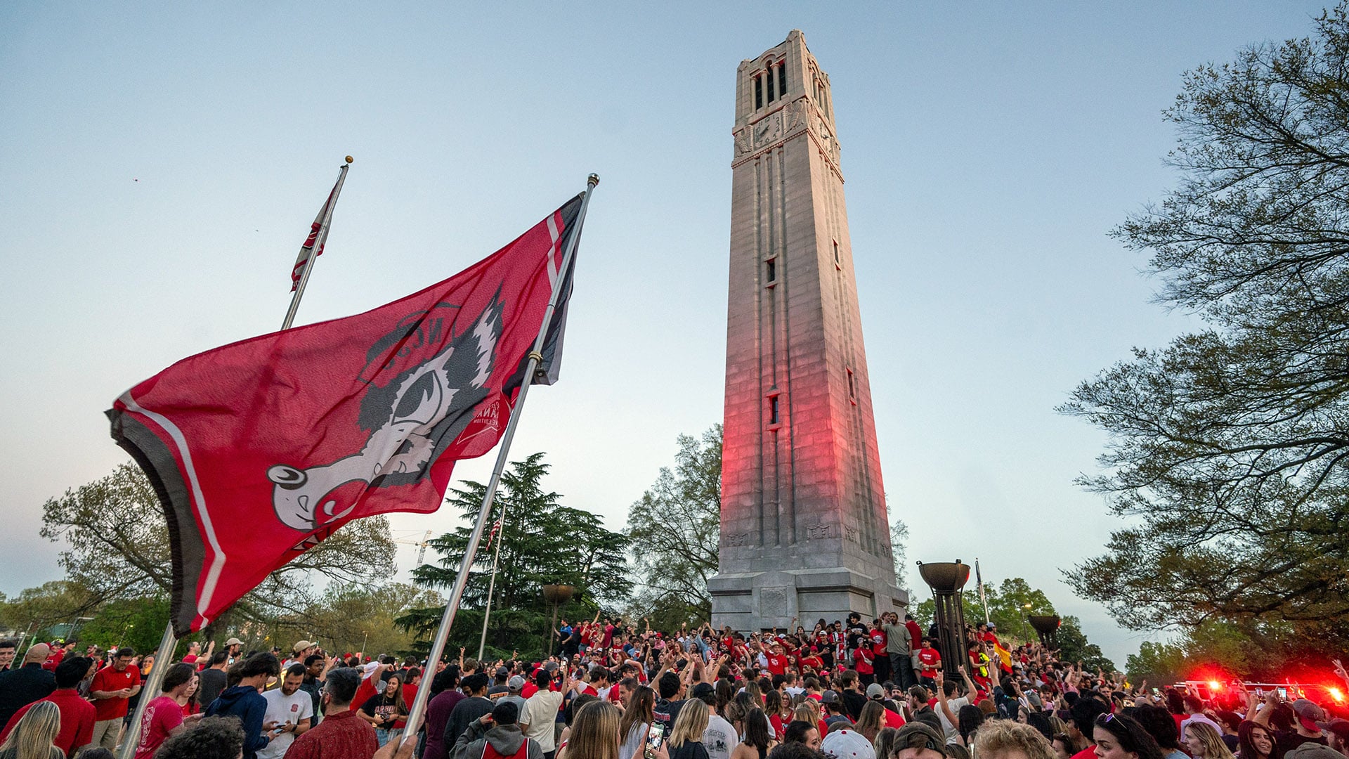 Students celebrate at the NC State Belltower after men's and women's basketball both advance to the Final Four of the 2024 NCAA Championship.