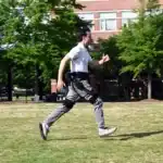 A man runs with support from a robotic exoskeleton trained using AI.