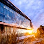 The sunset reflects on the windows of Hunt Library.