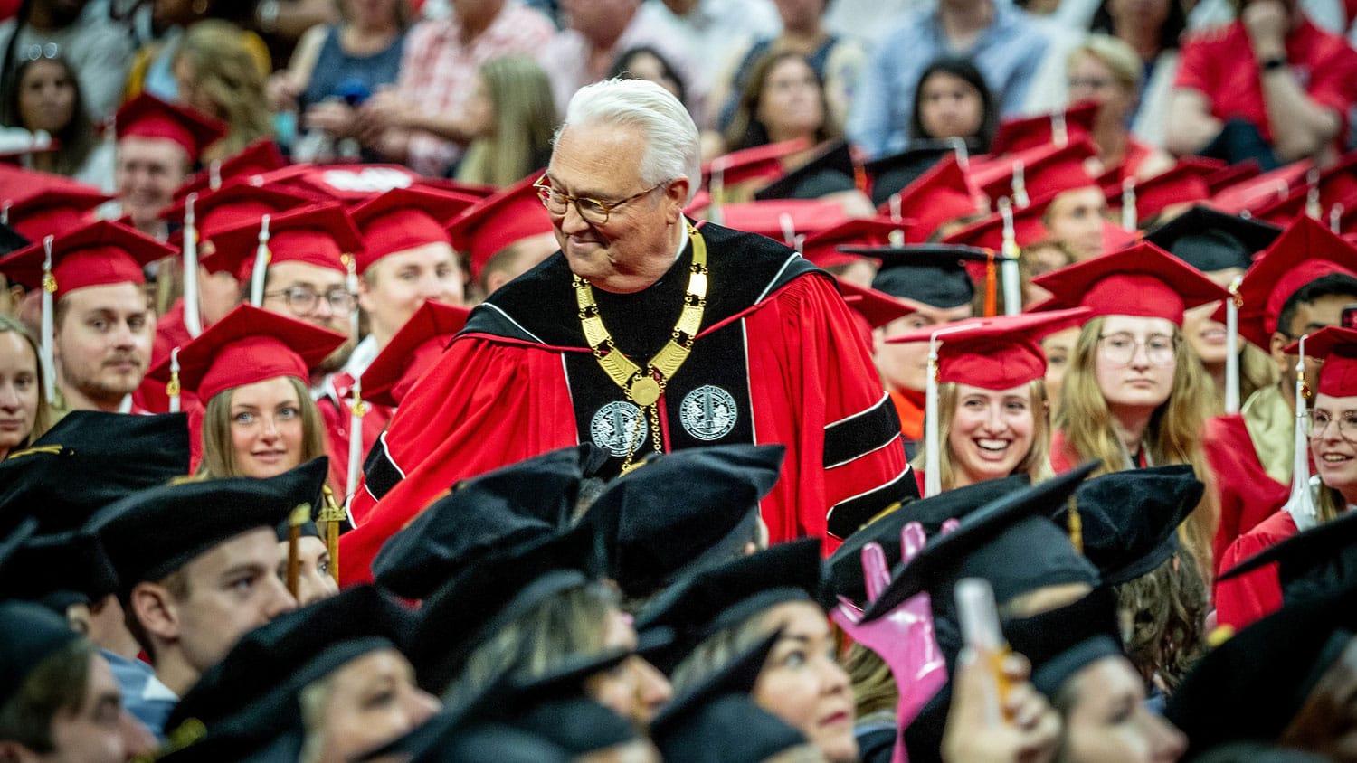 Chancellor Randy Woodson stands among a crowd of new graduates at commencement.