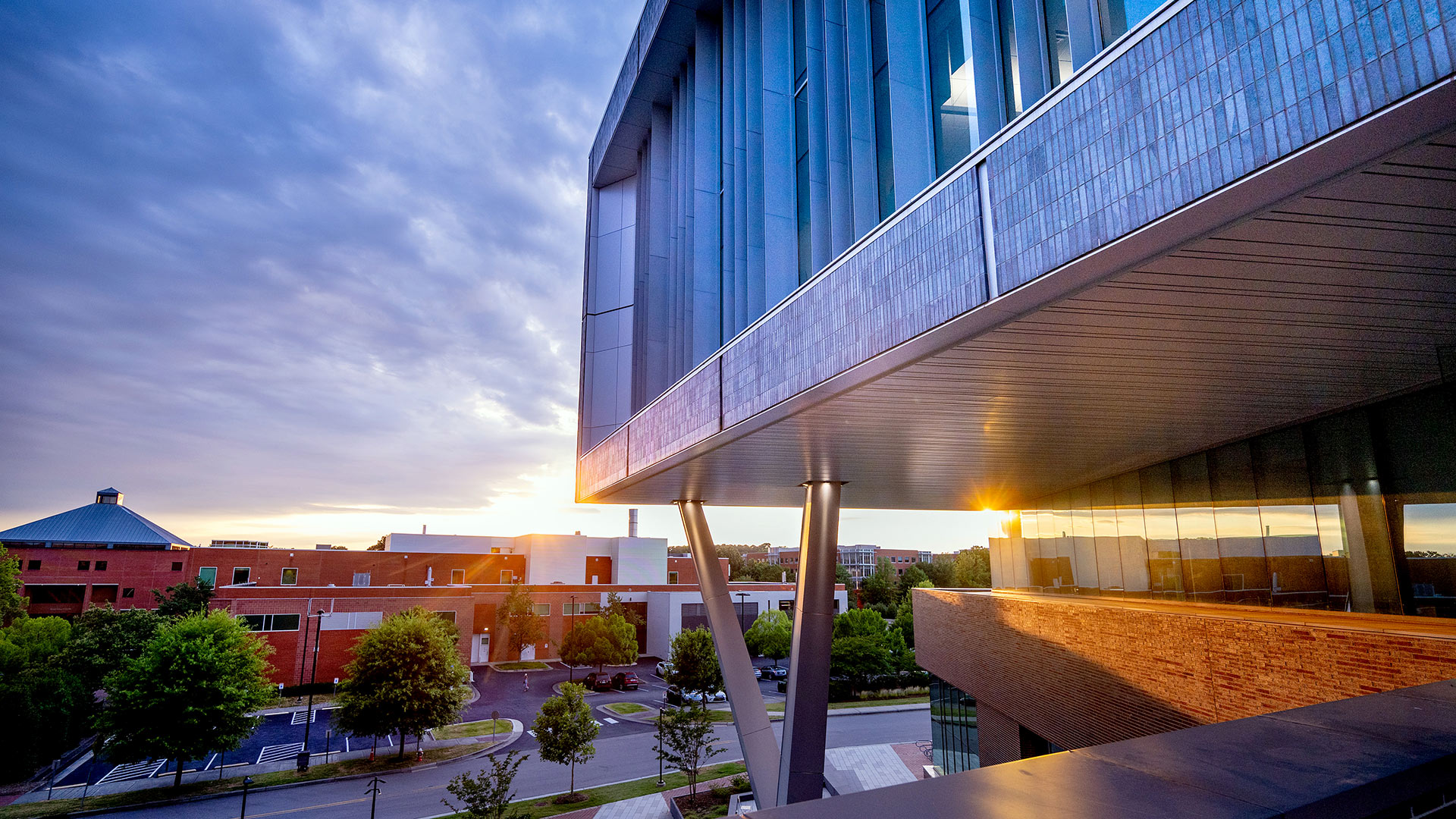 The sunset reflects on the windows of Fitts-Woolard Hall.