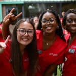 Three new CVM students hold up wolfies during an orientation event.