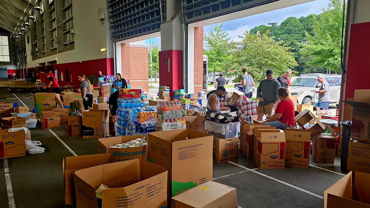 Student-athletes, staff and volunteers load boxes with supplies to be shipped to western North Carolina at the Close-King Indoor Practice Facility on Wednesday.