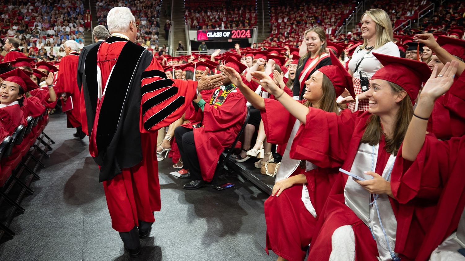 Chancellor Woodson high fives students at graduation.